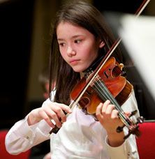 Young girl playing a string instrument